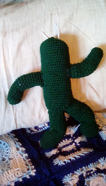 A crocheted cactuar from the Final Fantasy franchise. It's a cactus with eyes and mouth, all widened as if in surprise. Final Fantasy Cactuar