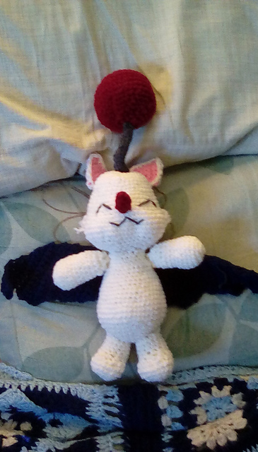 It is white in color, with navy wings and a large red bobble on an attena. Moogle 1