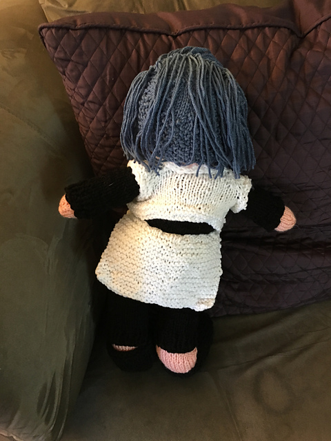 A knit doll of Maria from Star Ocean: Anamnesis.She's got blue shoulder-length hair with long bangs brushed to one side. This is the back view, showing a better view of the white jacket and sarong. Maria from Star Ocean: Anamnesis, back view